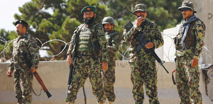 Afghan National Army (ANA) soldiers keep watch at the gate of a British-run military training academy Camp Qargha, in Kabul yesterday.