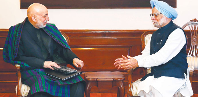 Indian Prime Minister Manmohan Singh (R) talks to Afghan President Hamid Karzai at Singhu2019s residence in New Delhi yesterday.