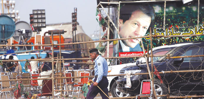 A policeman walking past a campaign truck of Imran Khan, chairman of the Pakistan Tehreek-e-Insaf political party, in Islamabad.