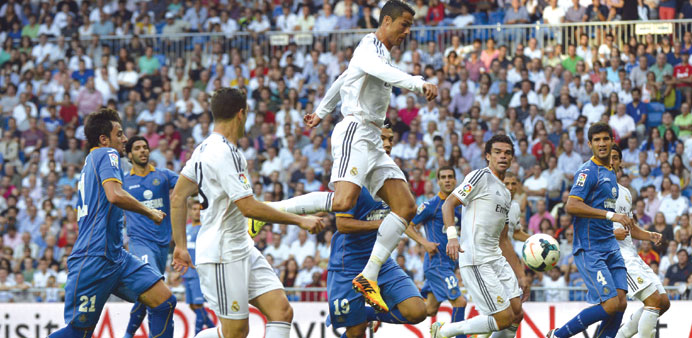 Real Madridu2019s Portuguese forward Cristiano Ronaldo (centre) jumps for the ball during the La Liga match against Getafe CF in Madrid yesterday. (AFP)