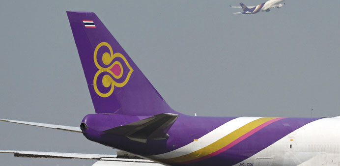 File photo shows a Thai Airways aircraft taking off past the tail of a cargo Thai Airways plane, at Bangkoku2019s Suvarnabhumi international aiport.