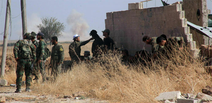 Syrian regime soldiers rest in an area around Kweyris military airport, in the eastern Aleppo province