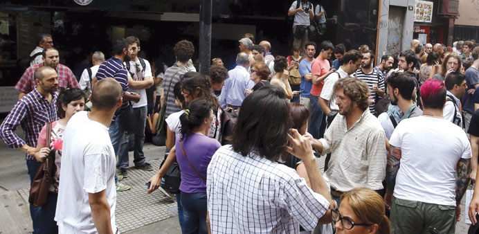 People gather outside the Federal Authority on Audio Visual Communications Services (AFSCA) headquarters in Buenos Aires yesterday