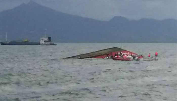 Rescuers search for survivors next to the capsized passenger ferry off Ormoc City, central Philippines.