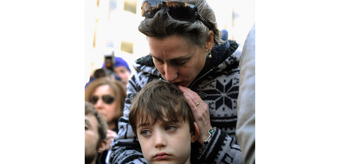People participating in an interfaith memorial service at a makeshift memorial for Boston bombing victims at the intersection of Boylston Street and B