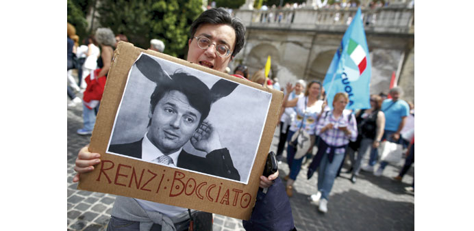 A demonstrator holds a placard with a picture of Renzi and the words u2018Renzi: failedu2019 during a protest against education reform in Rome.