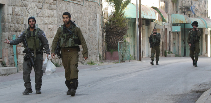 Israeli security forces walk near the site of a Palestinian attack