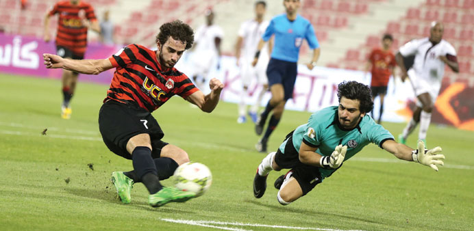 Al Rayyanu2019s Ahmed Alaeddine scores past Al Markhiya goalkeeper Jassim al-Hail in the Emir Cup opener yesterday.