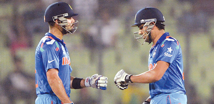 Indiau2019s Rohit Sharma (right) celebrates with teammate Virat Kohli after hitting a boundary during the ICC World Twenty20 tournament against Bangladesh