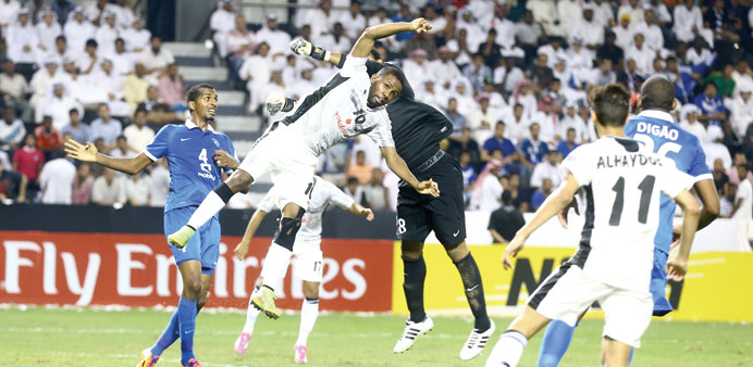 Al Hilal goalkeeper Abdullah Alsdairy (in black) clears an attempt by Al Saddu2019s Khalfan Ibrahim (#10) during the AFC Champions League quarter-final se