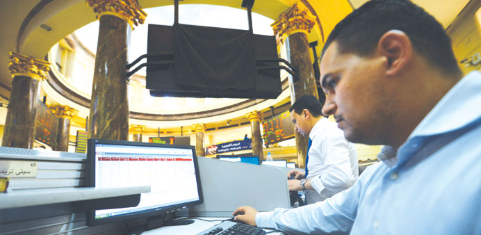 Traders work at the Egyptian Stock Exchange building in central Cairo. After being battered this year by the local political crisis, Egypt may stay un