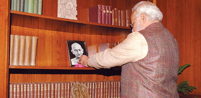 Prime Minister Narendra Modi pays a floral tribute over the portrait of Mahatma Gandhi after taking office at South Block in New Delhi yesterday.