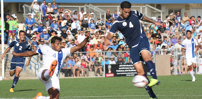 Guam's Travis Nicklaw attempts a shot as India's Arnab Kumar Mondal extends to try to block