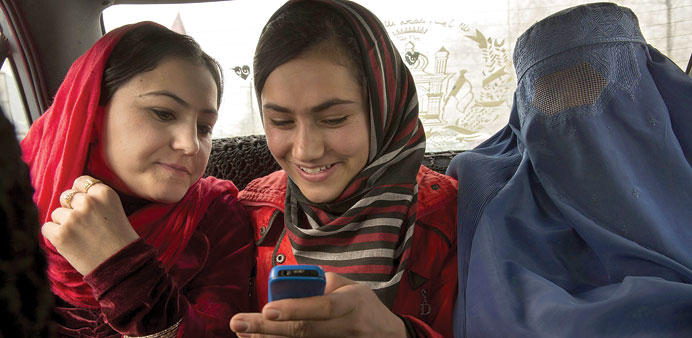 BETTER DAYS: Ghazalan Koofi, from left, looks at pictures on the phone of her sister Oranous Koofi as they take a taxi with their mother Shahgol Shah 