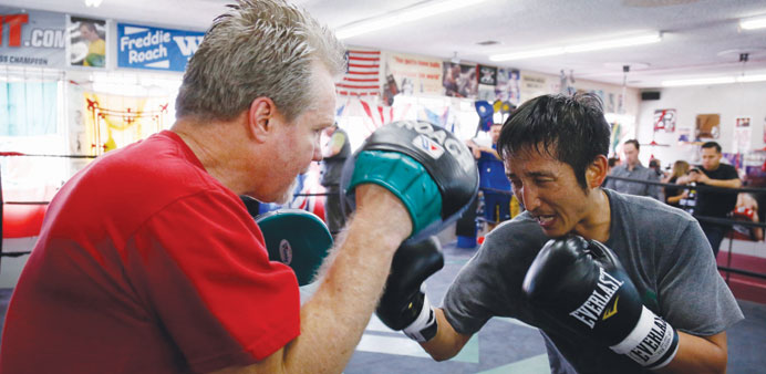 Two-time Olympic gold medallist Zou Shiming of China works out with trainer Freddie Roach (L) at Wild Card Boxing Club in Los Angeles.