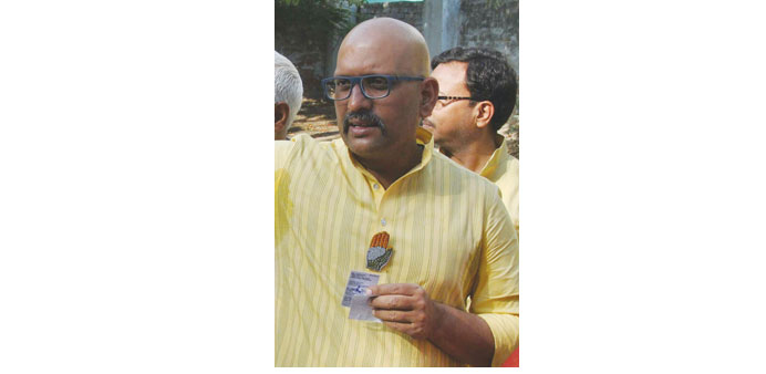 Congress candidate Ajay Rai is pictured wearing a lapel pin bearing his partyu2019s logo as he waits in line to vote in Varanasi yesterday. The Election C