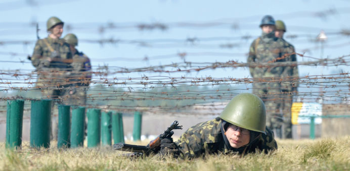 A former pro-European Maidan activist crawls during military exercises at a shooting range not far from Kiev.