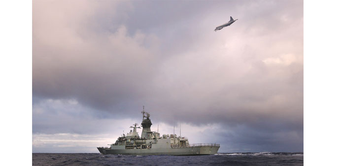 HMAS Perth in the southern Indian Ocean as an Orion P-3K of the Royal New Zealand Air Force searches for debris.