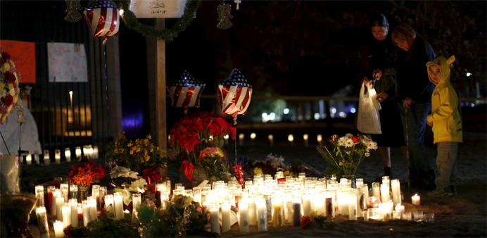 People stand by a pop-up memorial in San Bernardino, California