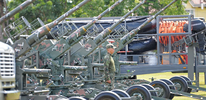 A Philippine Marine stands next to a newly acquired 40mm anti-aircraft cannon displayed during the navyu2019s founding anniversary celebration at a naval 