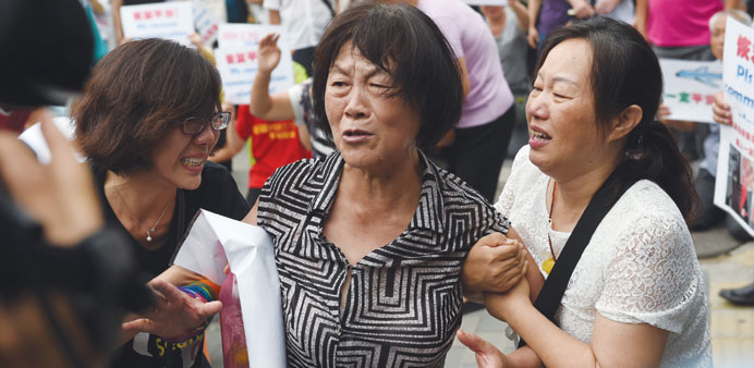 Relatives of passengers on  MH370 crying outside the Malaysian embassy in Beijing yesterday.