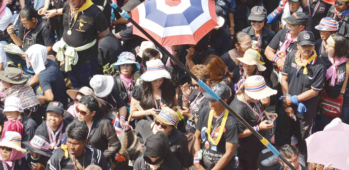 Anti-government protesters waving Thai flags during a rally outside the national police headquarters in Bangkok yesterday.