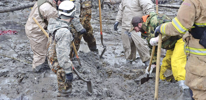 Personnel from the Washington National Guard join civilian workers in efforts to find missing persons following a deadly mudslide in Oso, Washington.