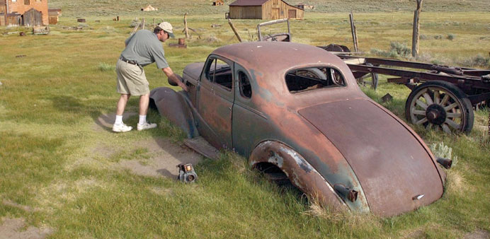 Peter Fay looks over a rusted car at the Bodie State Historical Park in Bodie, California. 