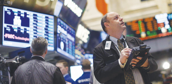Traders work on the floor of the New York Stock Exchange yesterday. US stocks were mixed in midday trade, with the Dow Jones Industrial Average down 0
