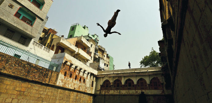 A boy jumps into a step well built inside the shrine of Sufi Saint Nizamuddin Auliya in New Delhi, yesterday. New Delhi and many other parts of India 
