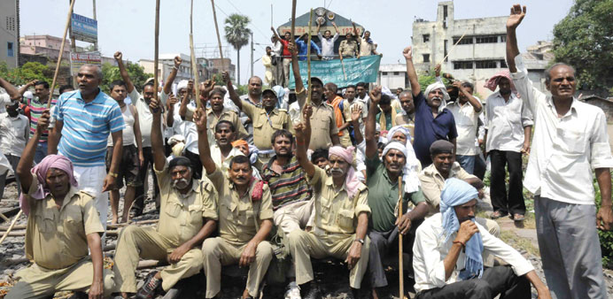 Home Guards sit on railway tracts as they stage a protest in Patna yesterday.