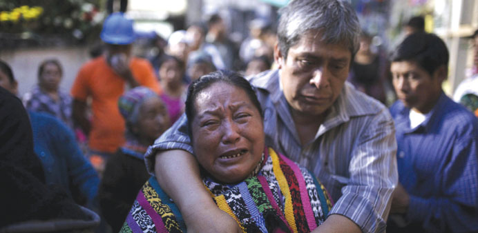 Relatives participate in the burial of Santos Etelvina Sontay, a victim of a mudslide in Santa Catarina Pinula, on the outskirts of Guatemala City.