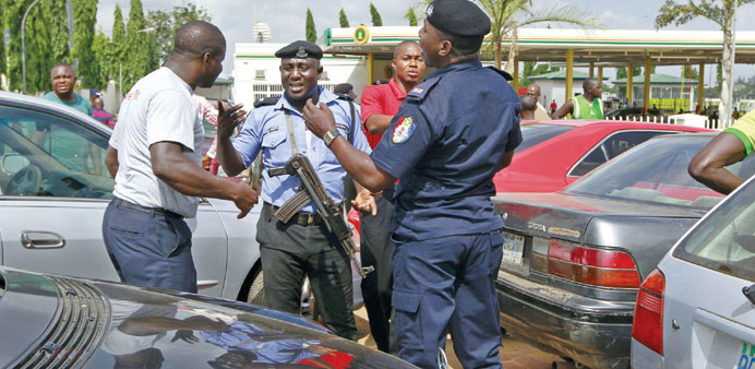 Security personnel speak with an angry motorist outside the NNPC petrol station in Abuja yesterday.