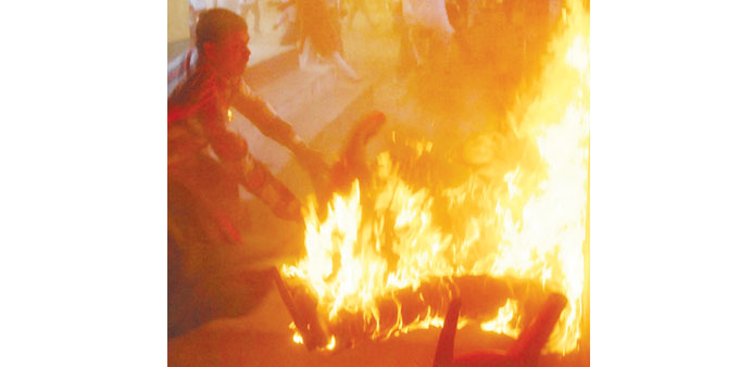People attempt to douse a blaze as BSP leader Kamruzzama Fauji and a man named by police as Durgesh Kumar Singh are engulfed in flames.