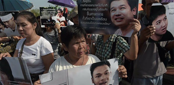 Supporters hold pictures of detained students as they take part in a protest in their support outside the cordoned-off military court