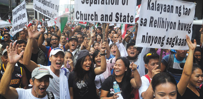 Followers of the conservative influential church Iglesia ni Cristo (Church of Christ) wave placards and shout slogans before finishing their street pr