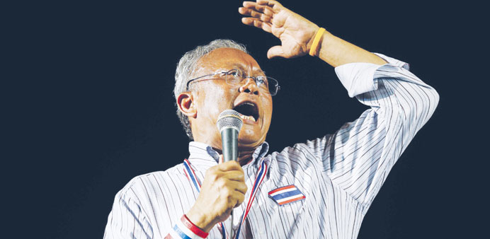 Protest leader Suthep Thaugsuban addresses a crowd of anti-government protesters outside the Government House in Bangkok yesterday.