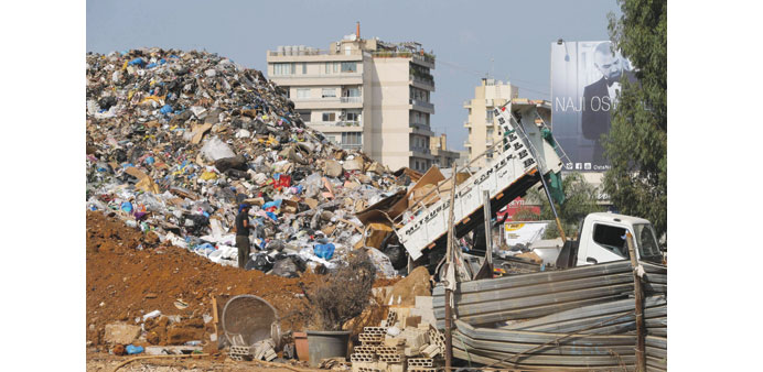 Workers unload a vehicle at a temporary garbage dump at the northern entrance of Beirut yesterday. 