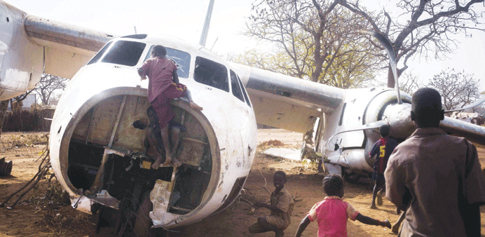 Young refugees play on an aircraft that crashed in November 2012 on an airstrip near the Yida refugee camp in South Sudan yesterday.