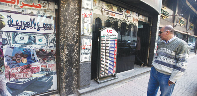 A man looks at a currency board in front of a exchange bureau in Cairo. Egyptians have rushed to buy dollars for fear of a messy devaluation, and bank
