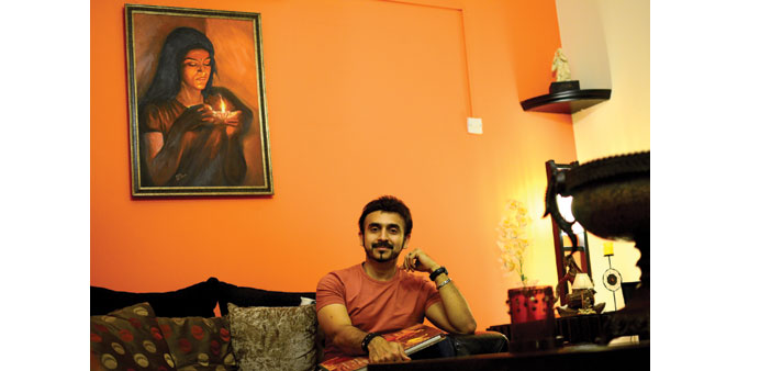 HOME BLISS: Padmanabhan at his residence with one of his paintings, that of his wife, in the background.     Photo by Anand Holla