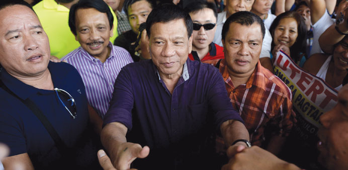 Davao mayor Rodrigo Duterte (centre) shakes hands with supporters outside a hotel in Manila yesterday.