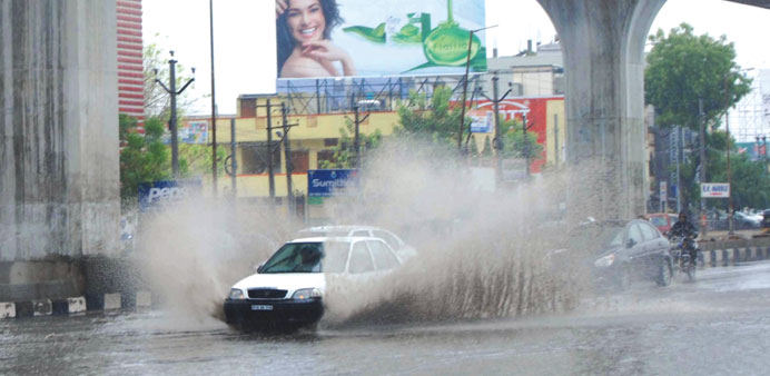Cars pass through a flooded road in Hyderabad after heavy rains yesterday.