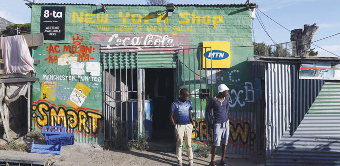 Residents stand outside a spaza convenience shop in Cape Townu2019s Imizamo Yethu township.