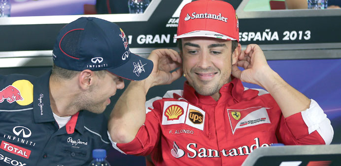 Spanish driver Fernando Alonso (R) of Scuderia Ferrari chats with German Formula One driver Sebastian Vettel (L) of Red Bull Racing during the press c