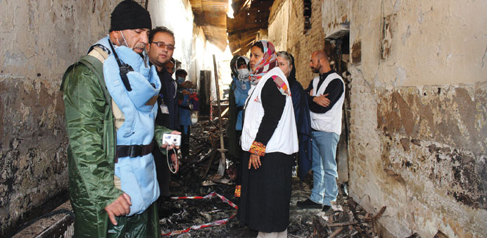 In this photograph taken on November 10,2015, an Afghan worker (left) talks to staff members in a charred corridor of the damaged Medecins Sans Fronti