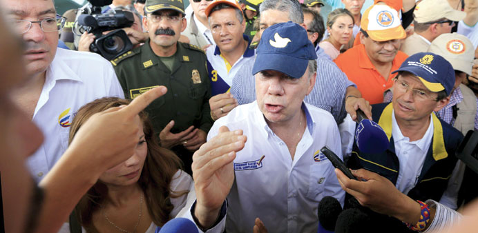 Colombiau2019s President Juan Manuel Santos speaks with a family deported from Venezuela during a visit at a temporary shelter in Villa del Rosario, Augus