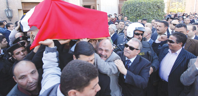 Mourners and policemen carry the coffin of police General Mohamed Saeed during his funeral in Cairo yesterday. 