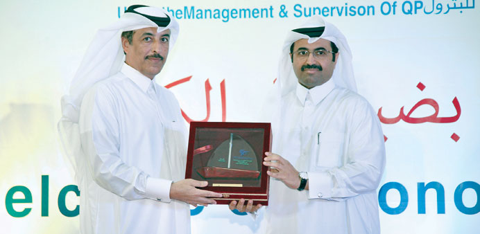 Dr Mohamed bin Saleh al-Sada presenting a token of appreciation to Qatargas chief operating officer (administration) Ghanim al-Kuwari who received it 