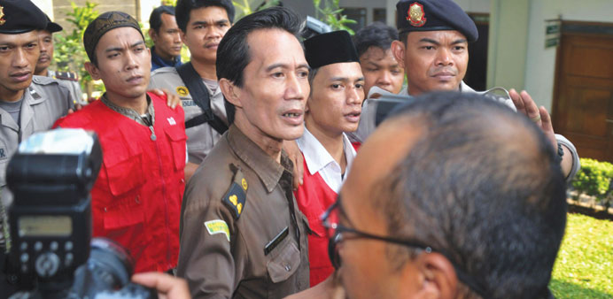 Indonesian cleaners Zainal Abidin (red vest right) and Syahrial (red vest left) being escorted to their trial in Jakarta yesterday.